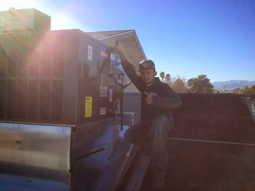 HVAC technician performing AC Tune-Up on a rooftop unit in Doolittle